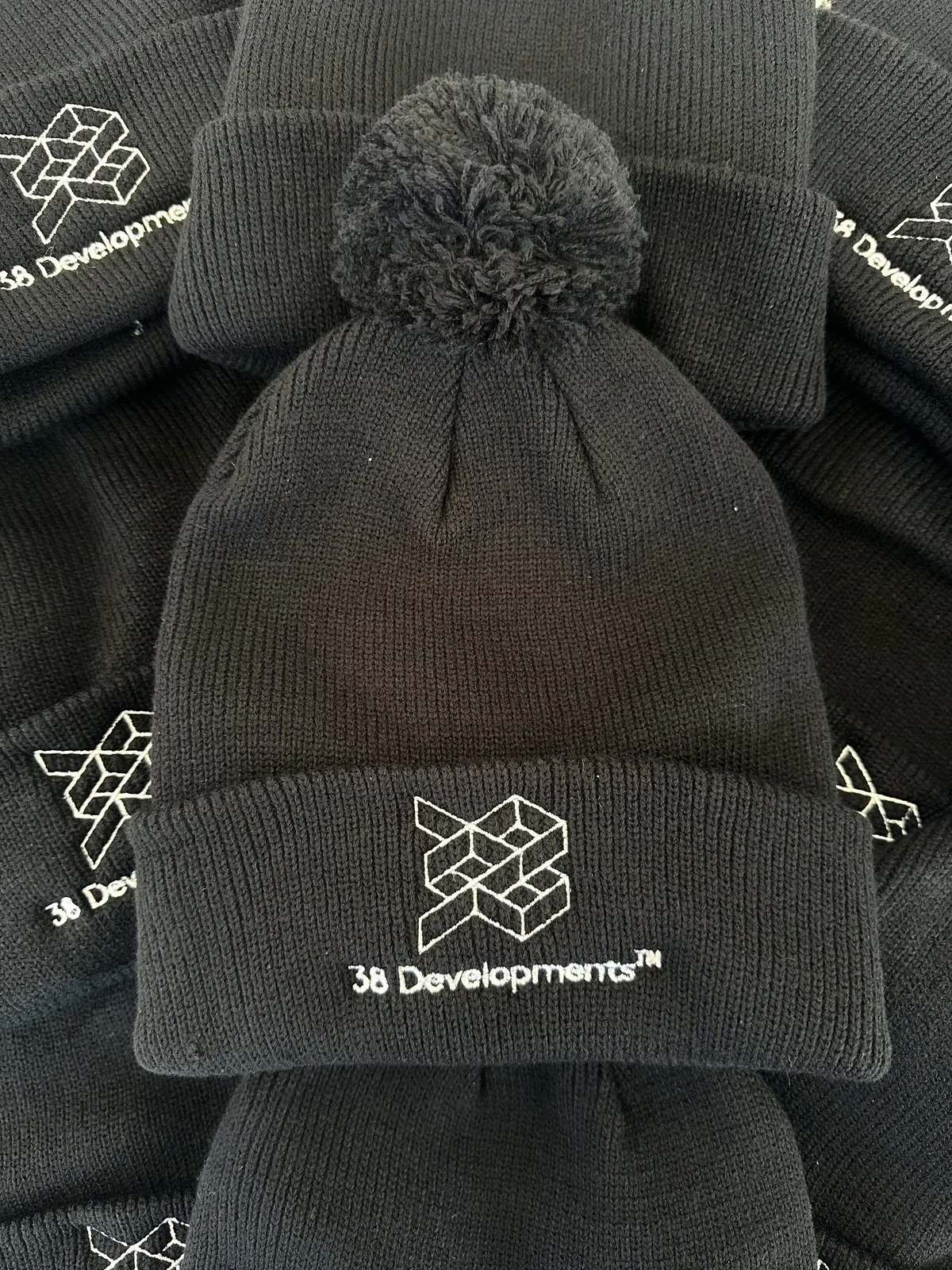 38 Developments embroidered caps piled with brand reading clearly